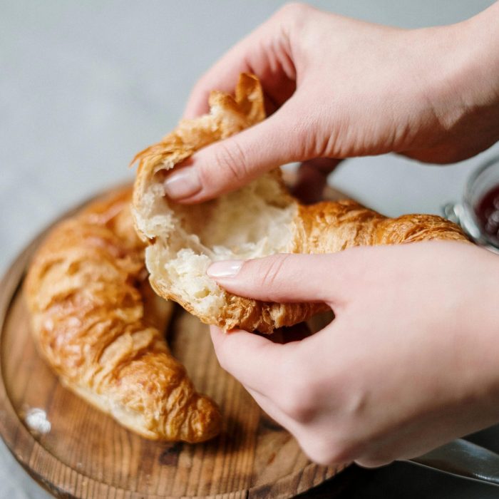 brewster-pastry-footer-hand-holding-croissant